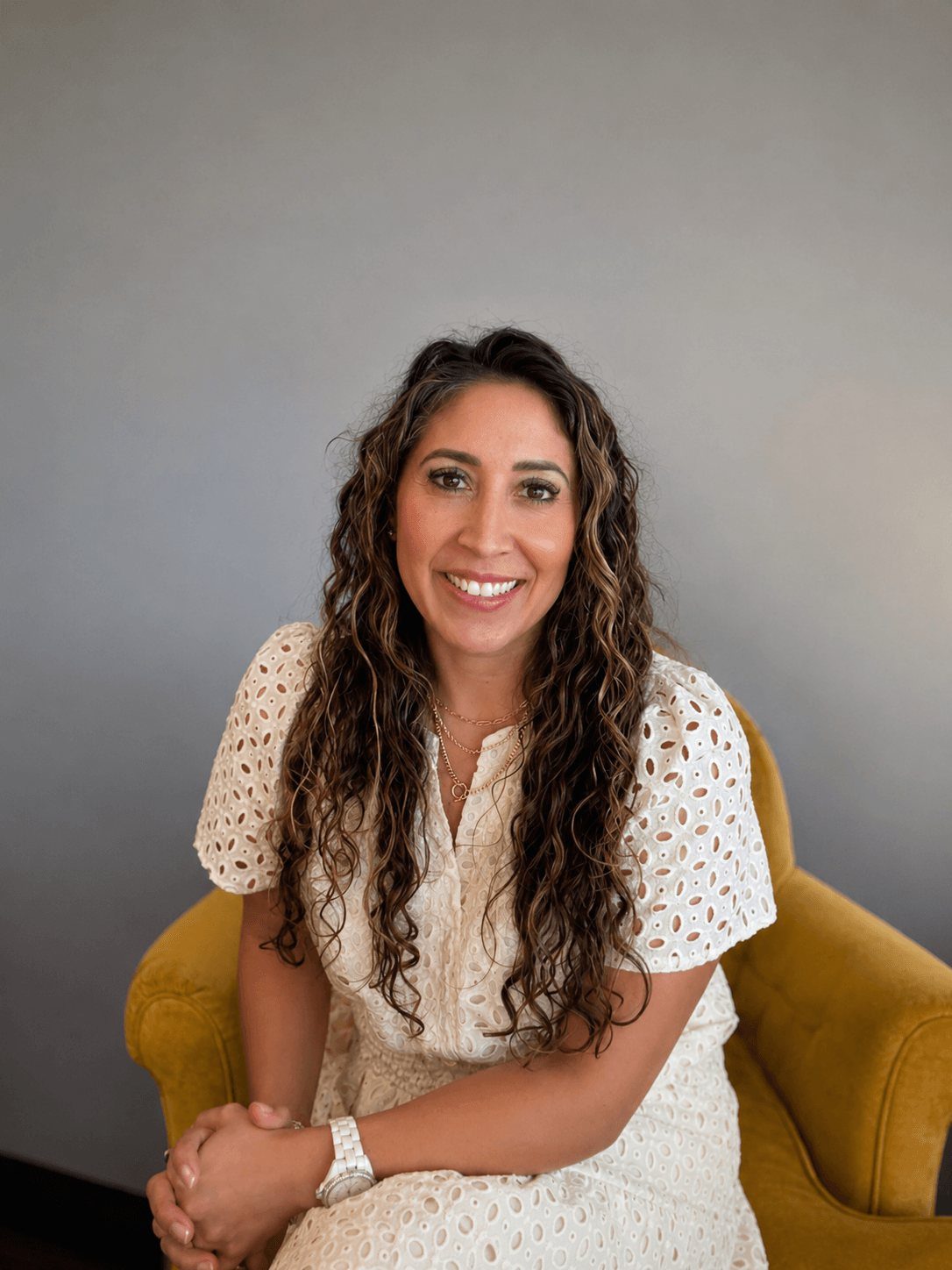 Vanessa Pate seated in a mustard armchair in her counseling office